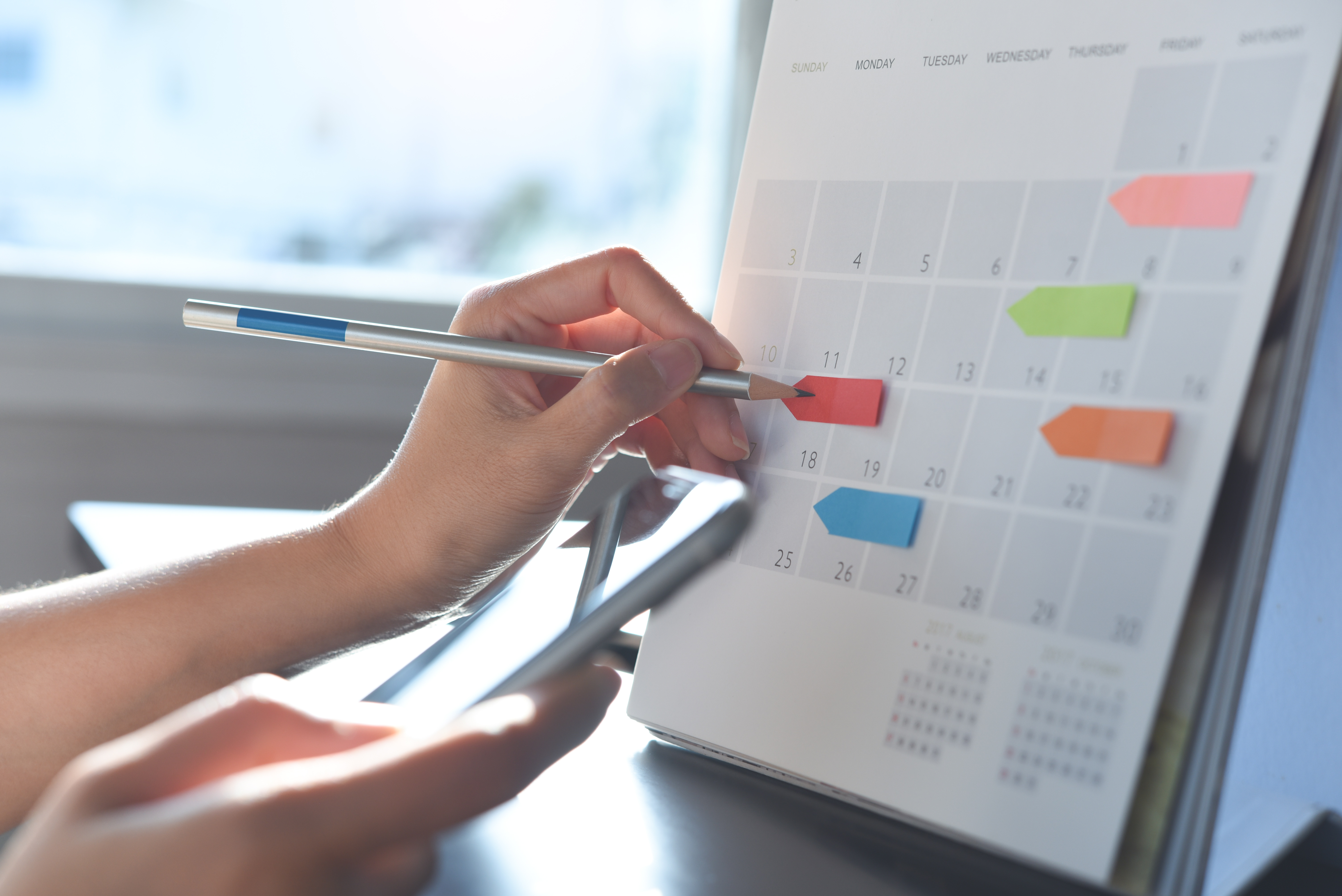 Vorteile von Zeitarbeit – vorrausschauende Planung im Kalender mit bunten Post-Its.